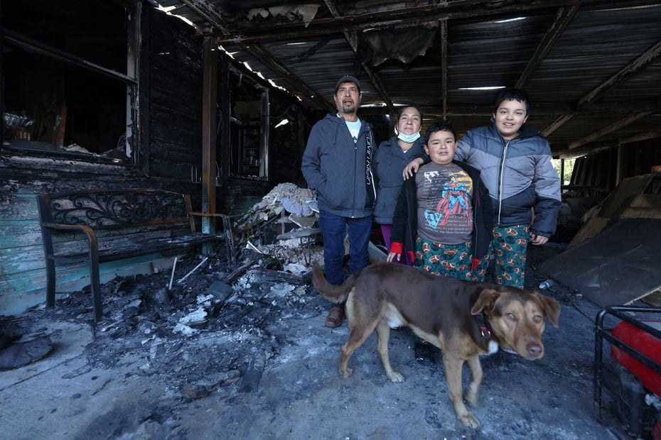 José Ángel Vera, Epigmenia Otero and their children Uriel and José Ángel pose with their dog Max in one of the rooms of their house in Oak Cliff that was destroyed in a fire.
