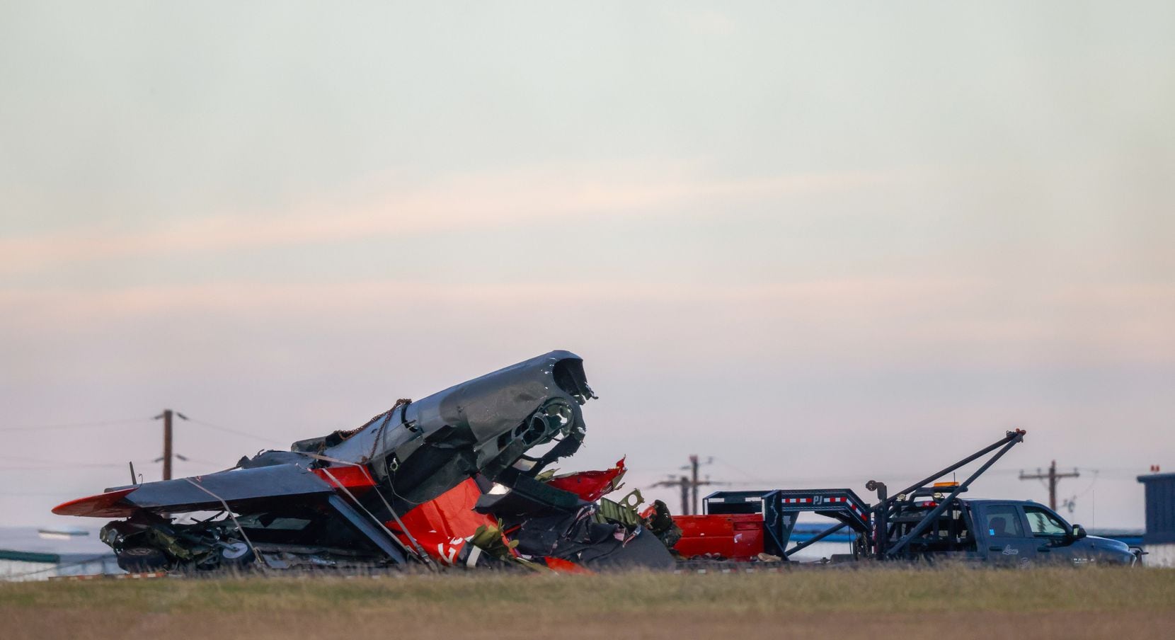 The damaged plane at the Dallas Executive Airport is removed by a trailer on Sunday, Nov....