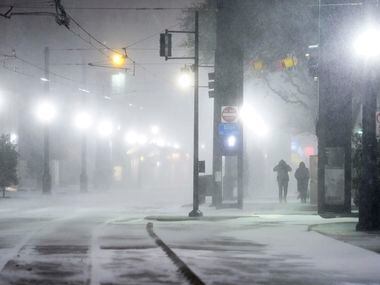 Blowing snow obscures people walking along Bryan Streen near the Pearl/Arts District station...