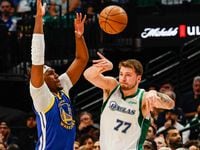 Dallas Mavericks guard Luka Doncic (77) makes a pass as he goes around Golden State Warriors...