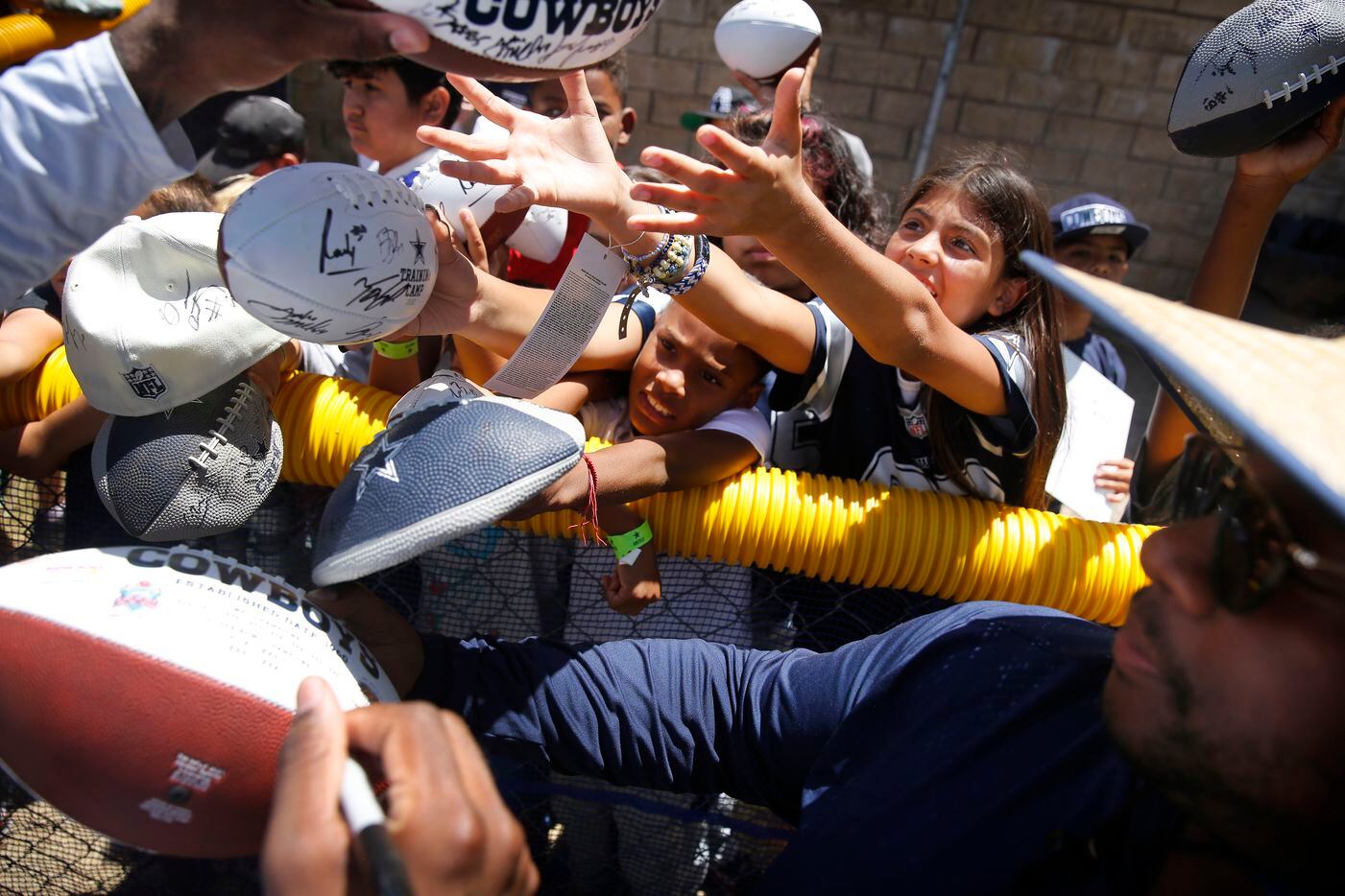 Young Dallas Cowboys fans reach for an autograph from running back Ezekiel Elliott following...