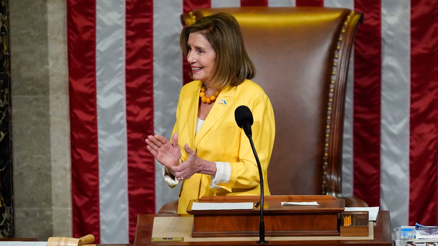 House Speaker Nancy Pelosi of Calif., claps after finishing the vote to approve the...