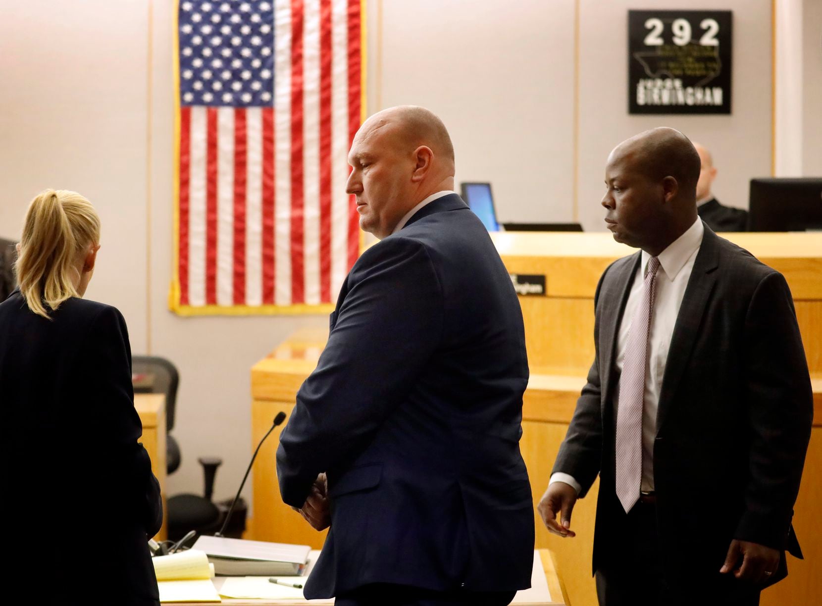 Former Dallas police officer Christopher Hess (center) walks out of his aggravated assault...