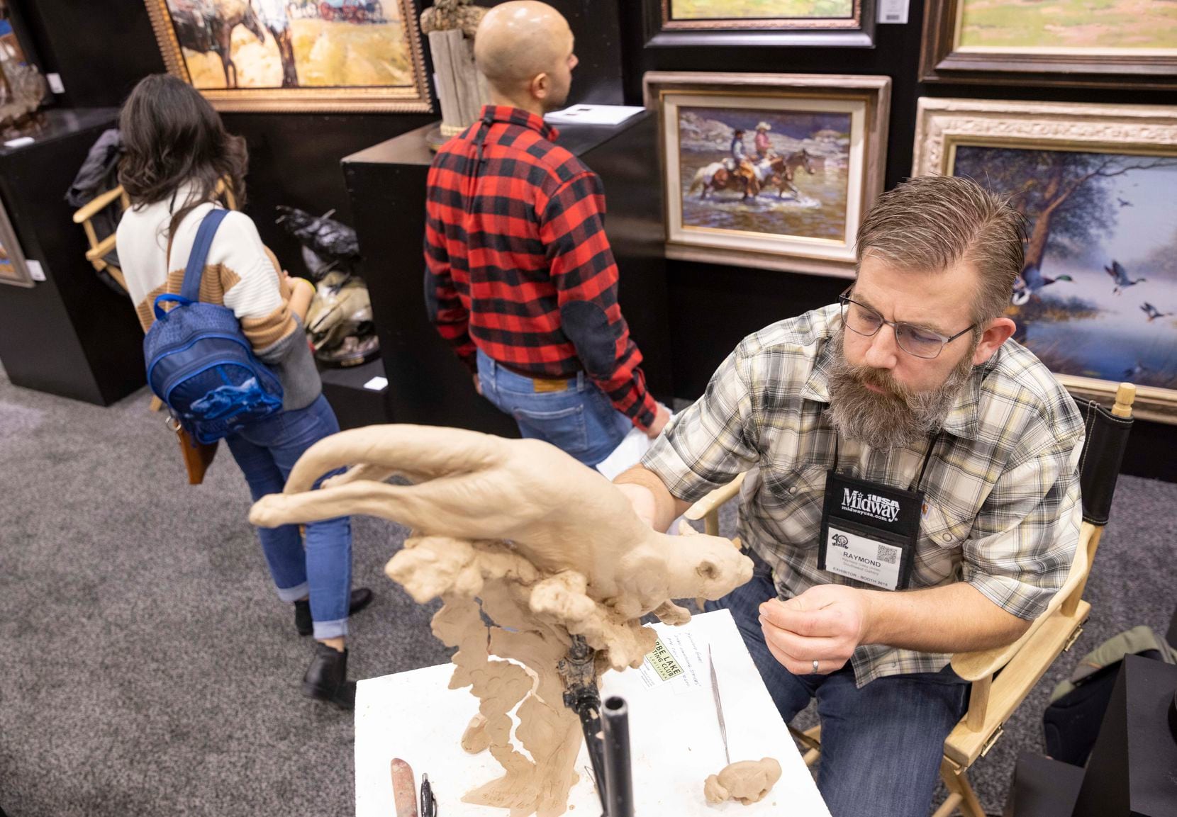 Raymond Gibby of Utah worked on a sculpture as people browsed the Southwest Gallery booth during the Dallas Safari Club Convention and Sporting Expo at Kay Bailey Hutchison Convention Center in Dallas on Jan. 7, 2022.