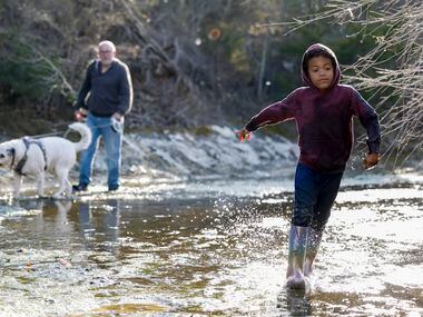 Judah Koontz, 5, splashes through Tenmile Creek on the Ladd property in Duncanville, Texas,...