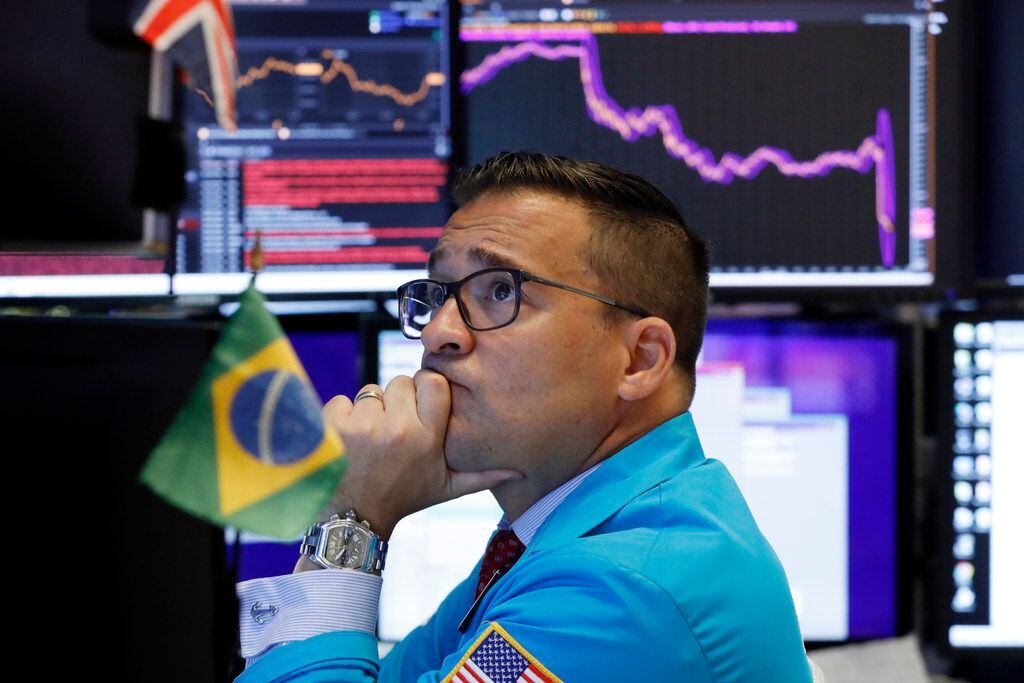 Specialist Paul Cosentino works on the floor of the New York Stock Exchange, Monday, Aug. 5,...
