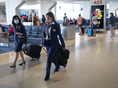 Les agents de bord d'American Airlines marchent le long du hall de l'aéroport international DFW.