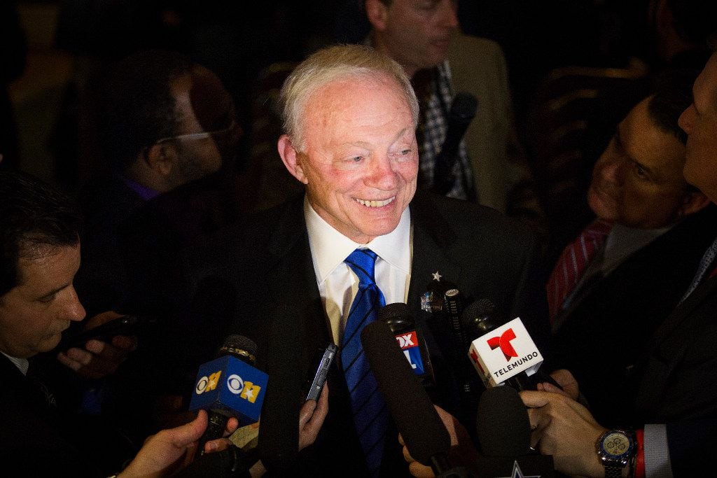 Dallas Cowboys owner Jerry Jones smiles as he is surrounded by media following a press...