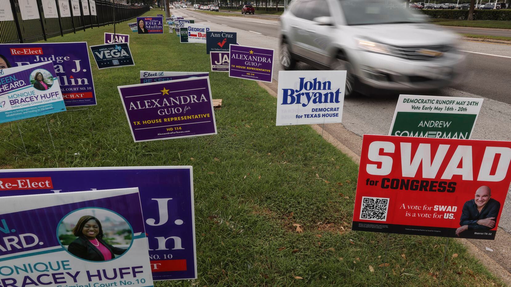 A car drives past signs outside Our Redeemer Lutheran Church, a voting location for Dallas...