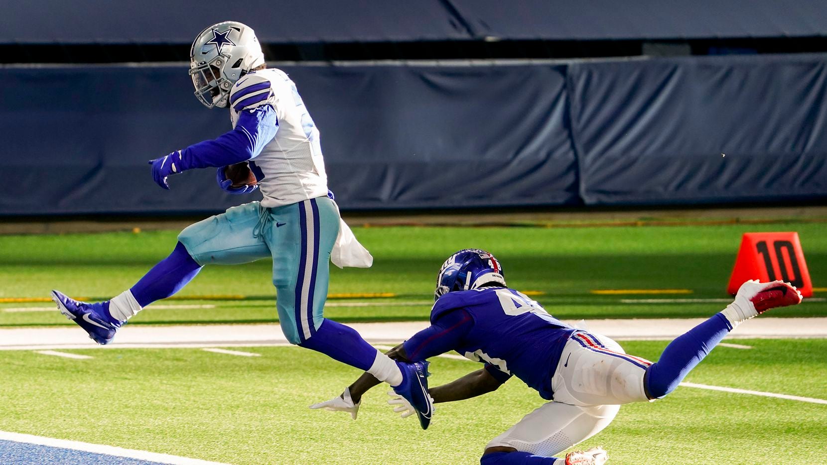 Dallas Cowboys running back Ezekiel Elliott scores past New York Giants linebacker Tae...