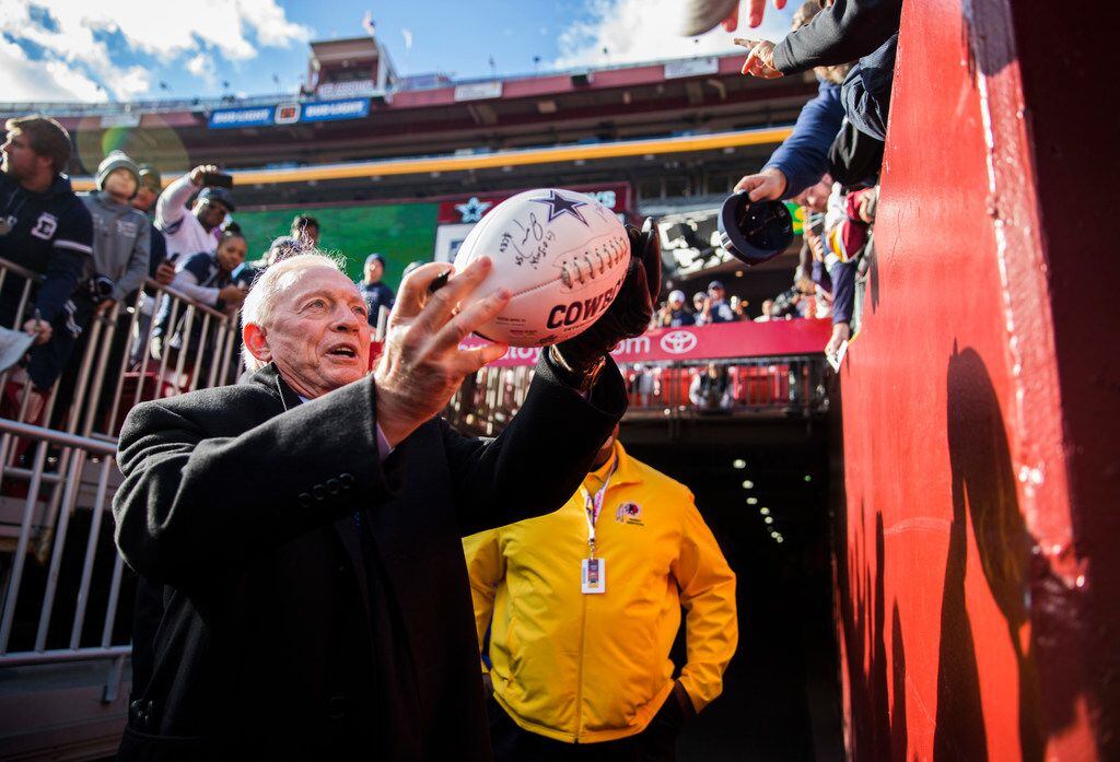 Dallas Cowboys owner Jerry Jones signs autographs for fans before an NFL game between the...
