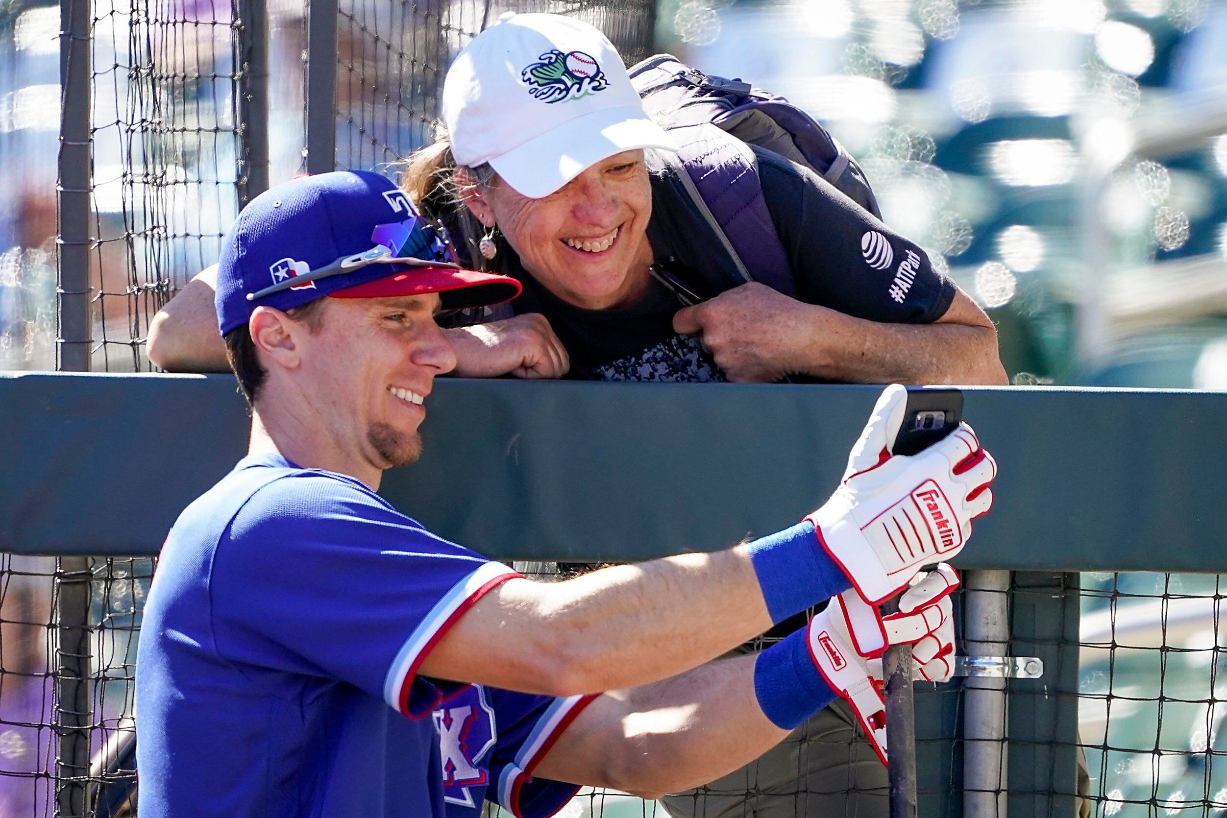 Texas Rangers infielder Matt Duffy takes a selfie with a fan before a spring training game...