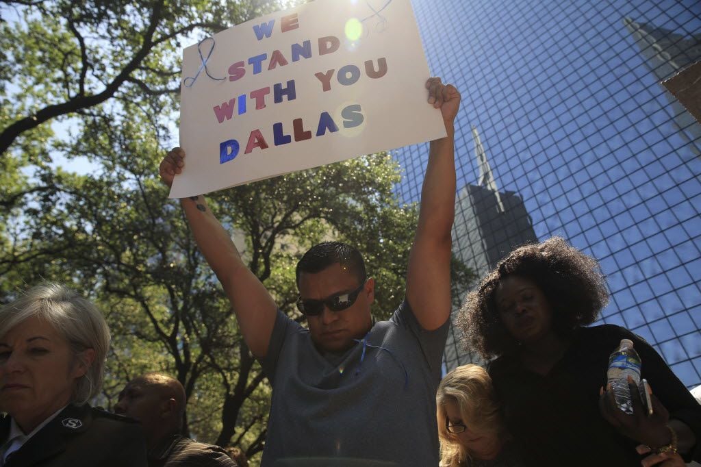 A sign of support among the crowd gathered for a vigil at Thanks-Giving Square in Dallas,...