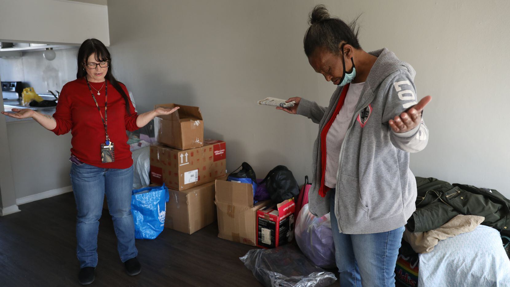 Faith Bartes (left), staff member at The Bridge Homeless Recovery Center, leads Patricia Freeman in prayer, blessing Freeman's new apartment in south Dallas on November 19, 2021. (Liesbeth Powers/Special Contributor)