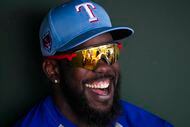 Texas Rangers outfielder Adolis García laughs in the dugout during the first inning of a...