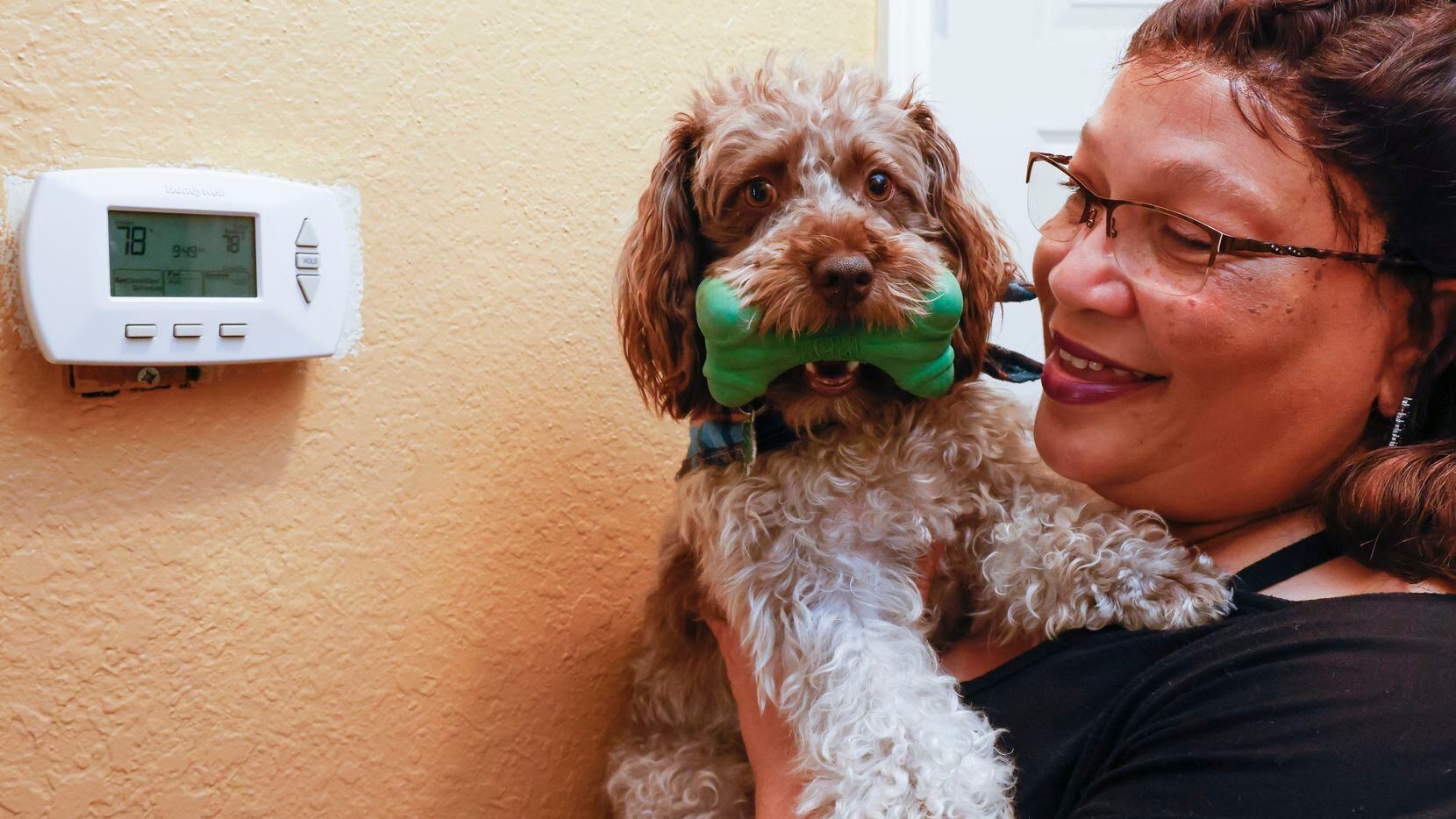 DeSoto resident Avery Anderson, 58, and her puppy Beignet by the thermostat at her home on...