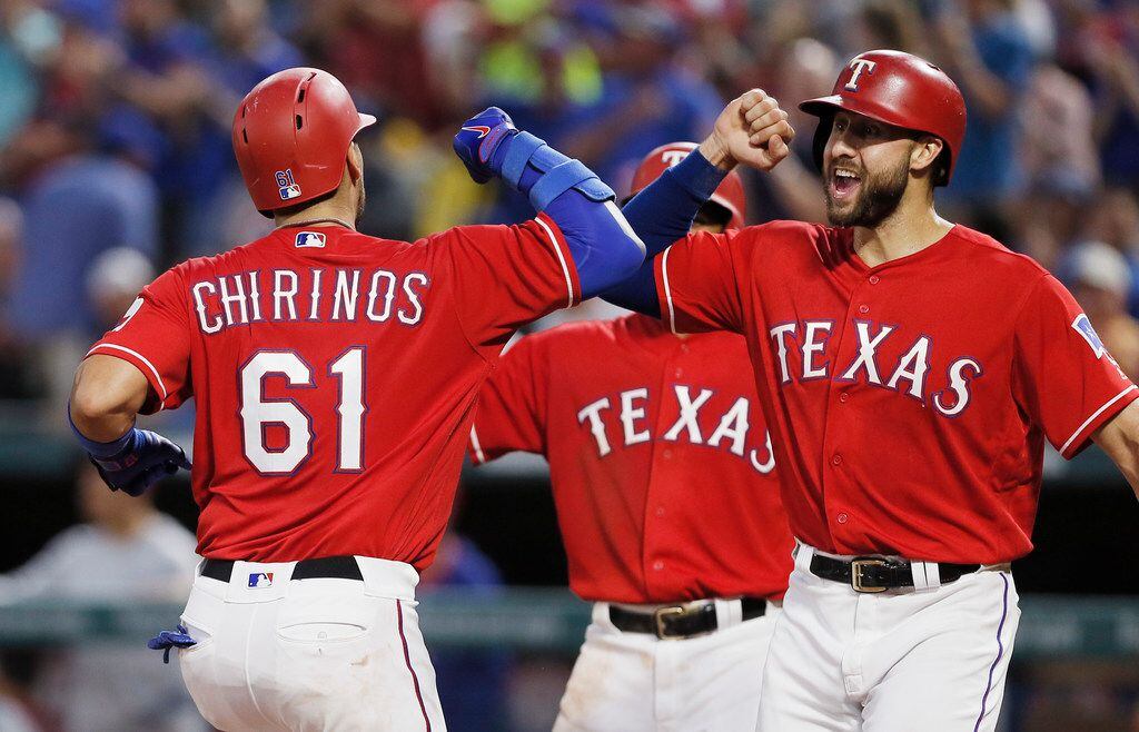Texas Rangers' Robinson Chirinos (61) is congratulated by Joey Gallo, right, after hitting a...