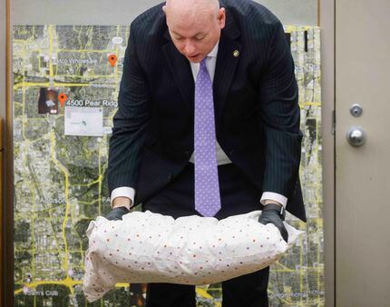 Prosecutor Glen Fitzmartin demonstrates with the pillow used to smother Lu Thi Harris, 81,...