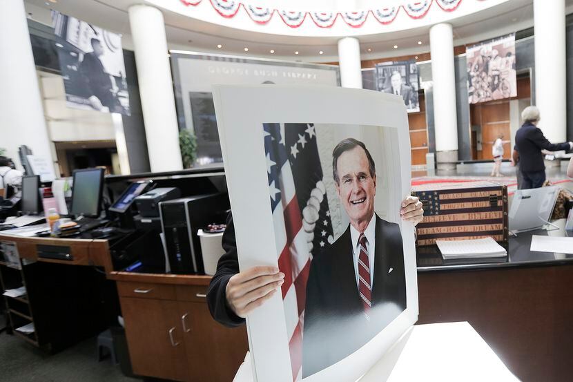 Una persona toma una fotografía del ex presidente George H.W. Bush en la George H.W. Bush...