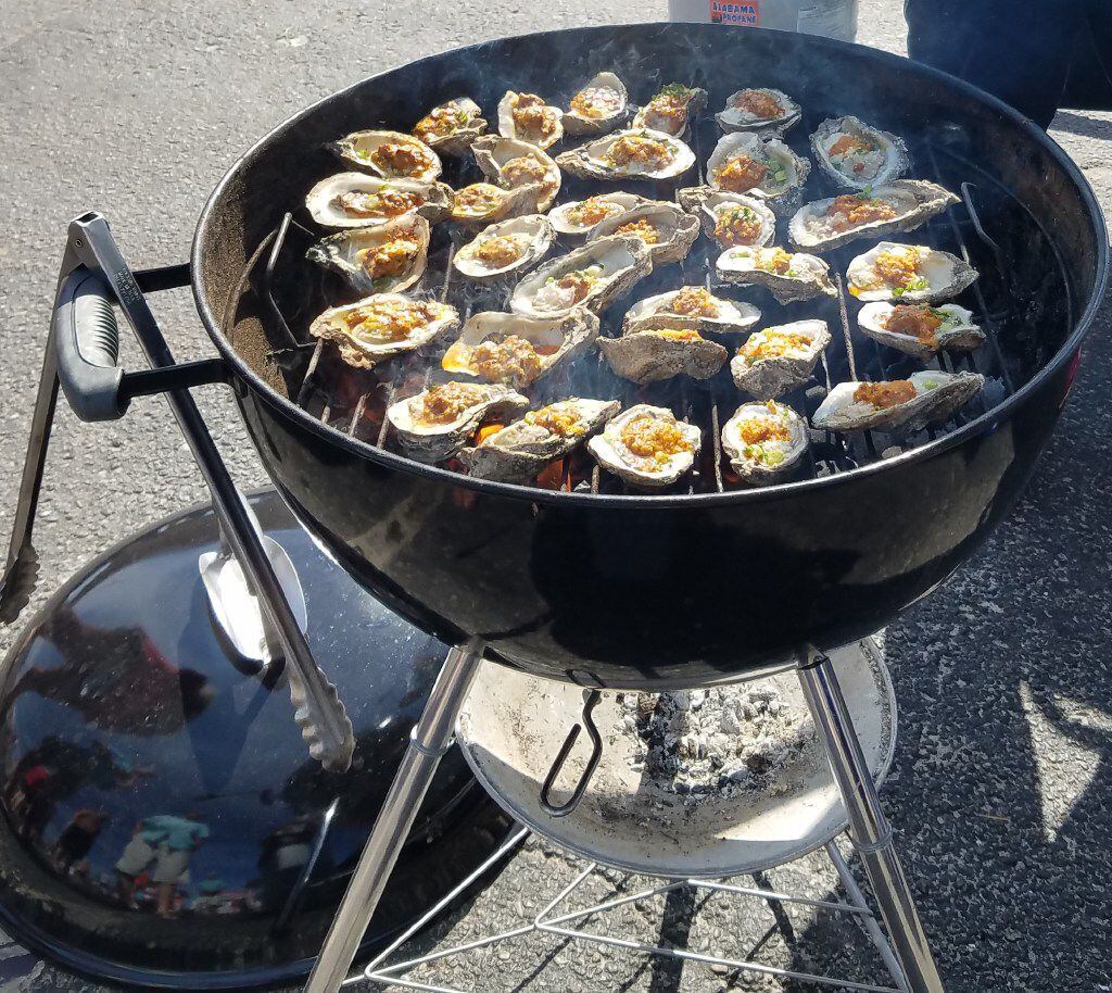 Oysters bubble on a grill during one of the many events at The Hangout, and indoor-outdoor...