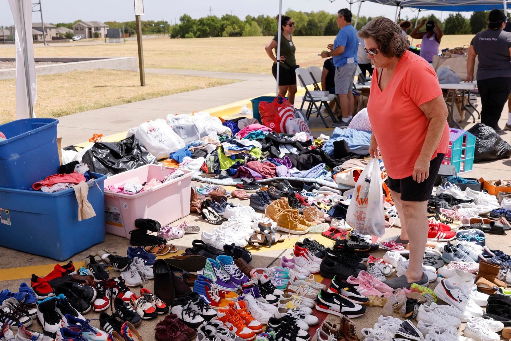 Sandra Johnson-Williams searches through donations of shoes Saturday. Johnson-Williams said...