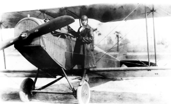 Pioneer aviator Bessie Coleman stands on the wheel of a plane in this 1920s photo. Coleman...