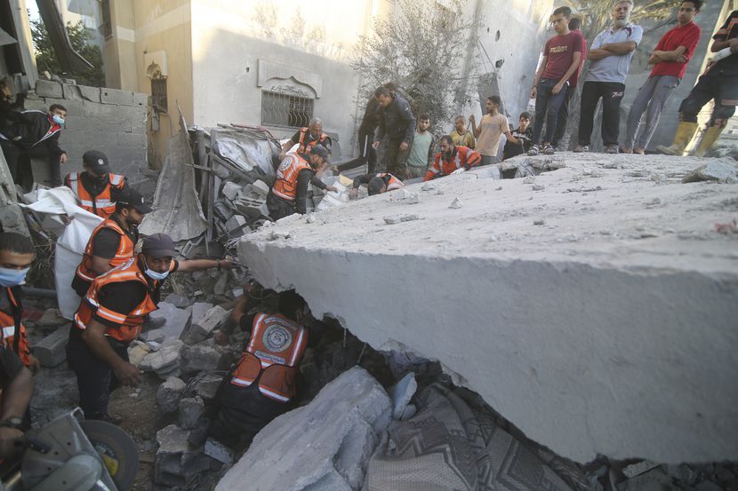 Palestinos buscan sobrevivientes entre los escombros del edificio de la familia Zanon, el...