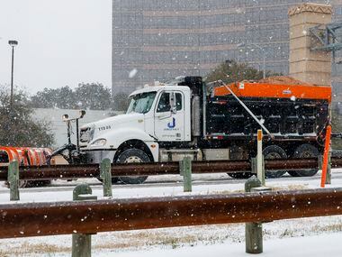 A snowplow and sanding truck clears the road along Chisholm Trail Parkway near downtown on...