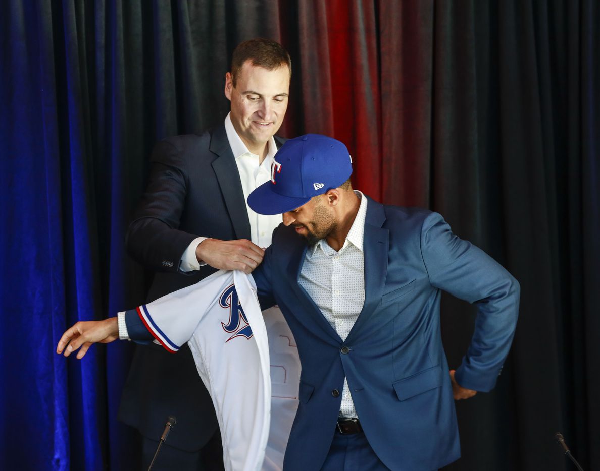 Marcus Semien puts on his jersey at a news conference at Globe Life Park in Arlington on...