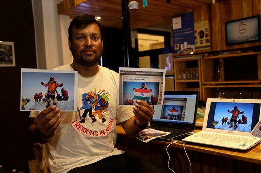 El alpinista Satyarup Sidhantha muestra en su mano derecha una fotografía donde sale él en...