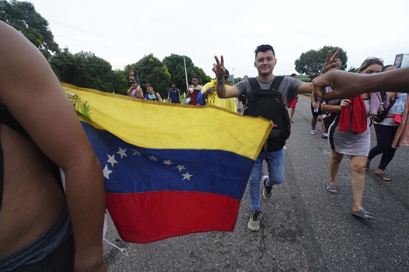 Migrantes mayormente venezolanos y centroamericanos avanzan a pie por una carretera de...