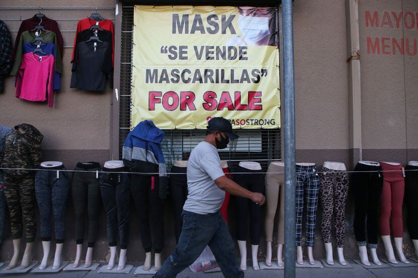 Una persona camina por enfrente de un negocio en el centro de El Paso donde se vende ropa y...