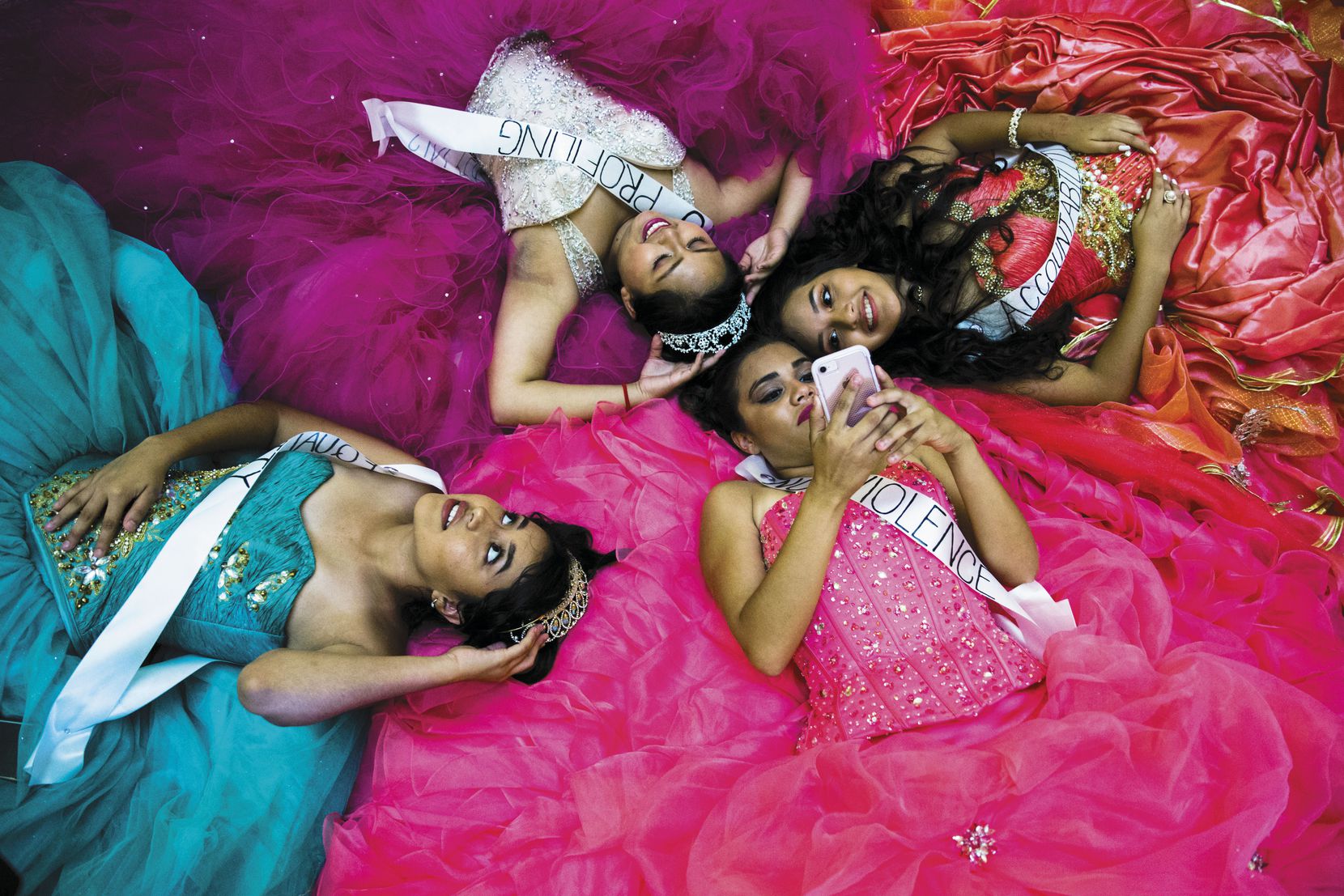 Clockwise from left: Evelyn Macias, 16, Viridana Sanchez, 16, Brenda Puente, 15, and Alesandra Lopez, 18, lie on the floor of the Capitol rotunda in Austin after they and other teenagers held symbolic quinceaneras to protest the sanctuary cities ban.