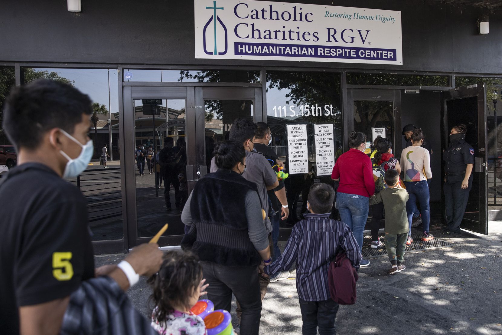 Families with very young children, likely under the age of six, arrive to the Catholic...