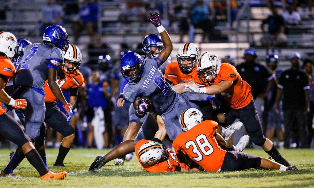 TXHSFB North Mesquite senior Samuel Inyang (9) is tackled by Haltom City defenders on a...