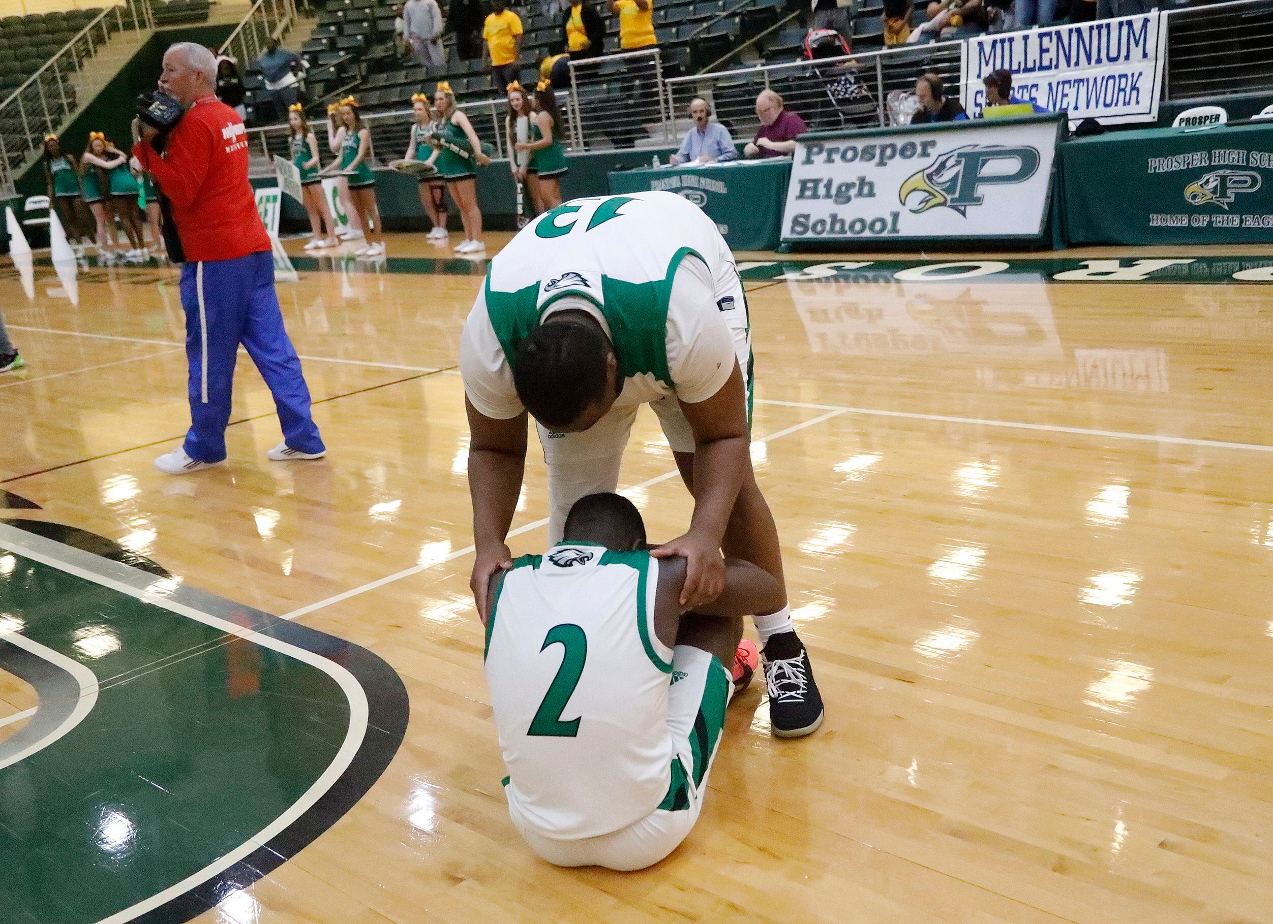 Tatum gaurd Kendall Wiliams (2) is consoled by center TyDarius Webb (13) after defeat in the...