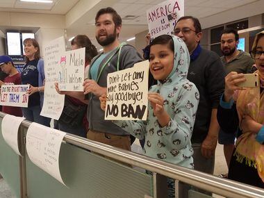 Dozens of protesters remained at DFW International Airport on Monday night waiting the...
