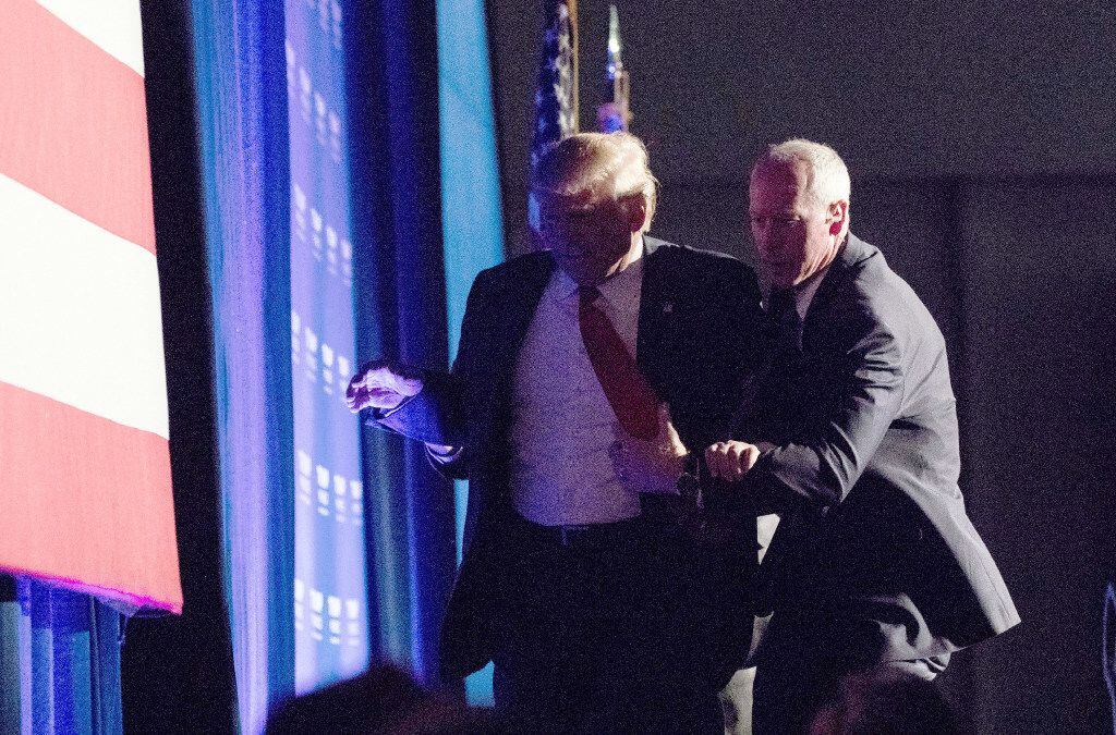A security agent quickly escorted Donald Trump off the stage at a Reno rally Saturday.
