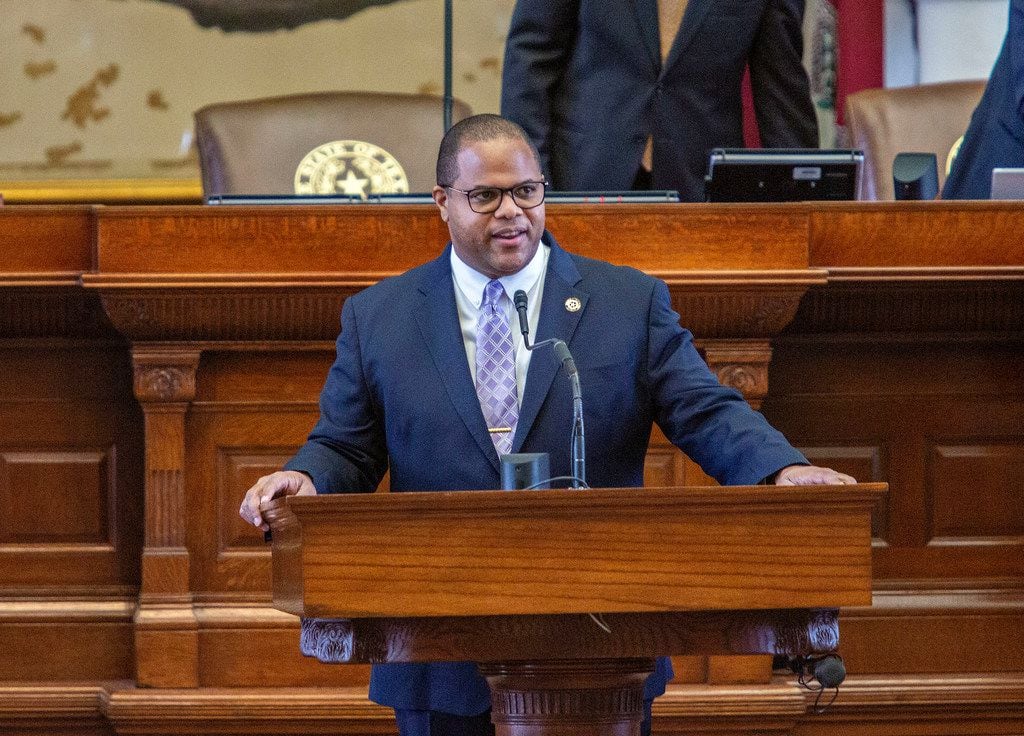 State Rep. Eric Johnson stands at the podium to recognize his staff on the House floor just...