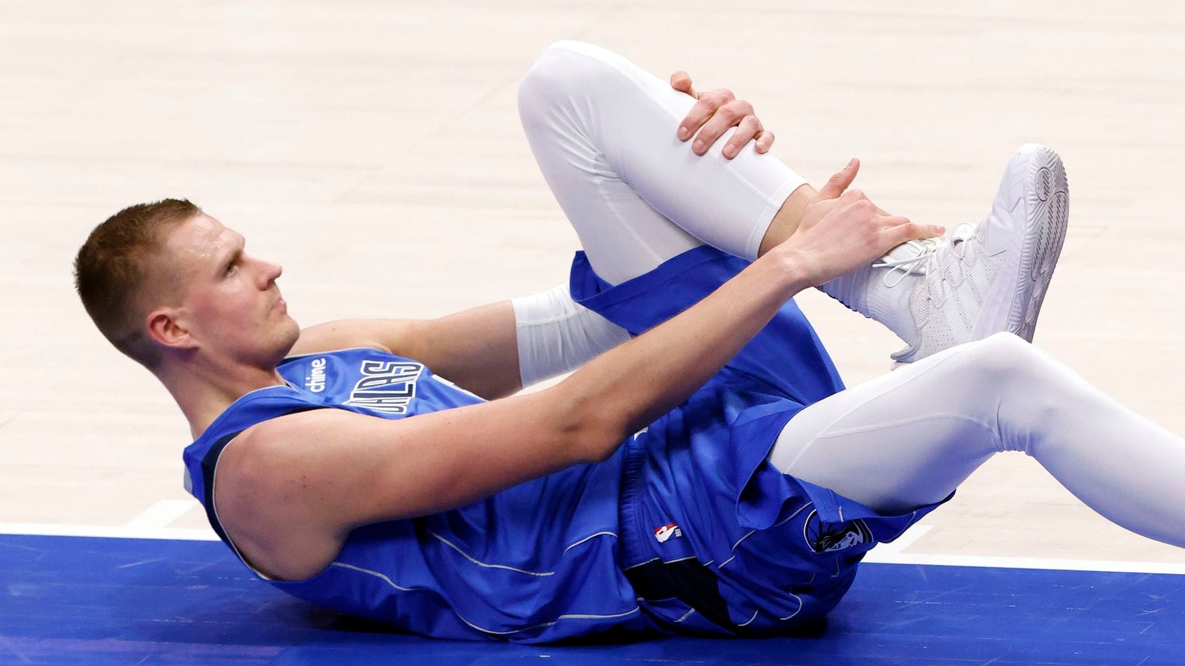 Dallas Mavericks center Kristaps Porzingis (6) grabs his ankle after falling to floor under the basket against the Los Angeles Lakers in the third quarter at the American Airlines Center in Dallas, Thursday, April 22, 2021. Porzingis limped off after the play.