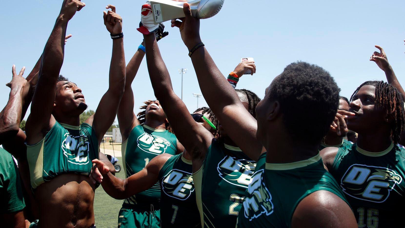 DeSoto Eagles players celebrate as they raise the Division 1 championship trophy after their...