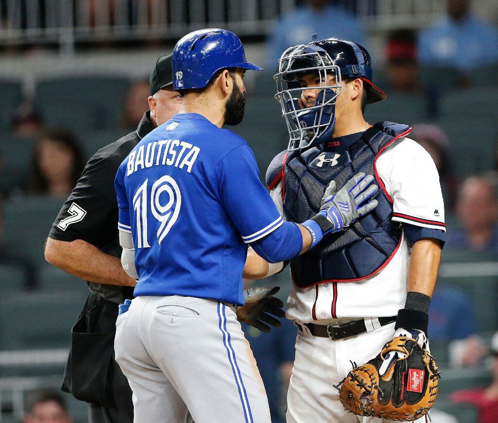 Toronto Blue Jays' Jose Bautista (19) exchanges words with Atlanta Braves catcher Kurt...