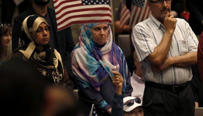 
				Aminah Hamed (centro) sostiene una bandera estadounidense durante la reunión del jueves...