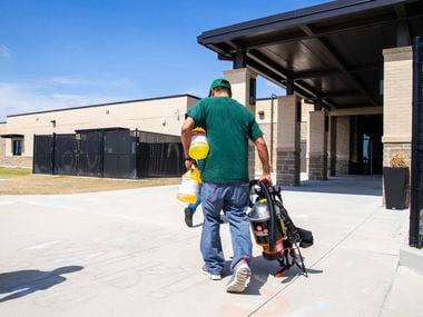 Custodian George Cox (right) carries a respirator and cleaning supplies into Jim Spradley Elementary School in Frisco, Texas, on Thursday, March 12, 2020. Frisco ISD custodial crews worked to disinfect campuses throughout Thursday in light of the COVID-19 global pandemic.