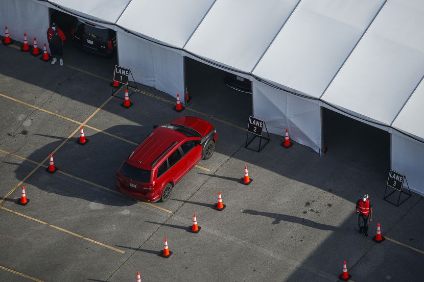A car enters the testing tent at Ellis Davis Fieldhouse in Dallas on Friday.