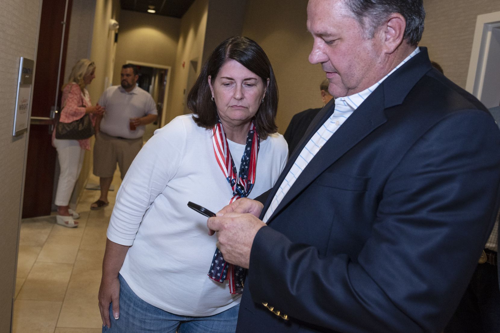 Susan Wright, District 6 Congressional candidate, left, peeks at the phone of Rick Barnes, Chairman of the Tarrant County Republican Party, as he showed Wright the latest poll results during an election night watch party at the Courtyard by Marriott hotel in Arlington, on Tuesday, July 27, 2021. Susan Wright was defeated by candidate Jake Ellzey.