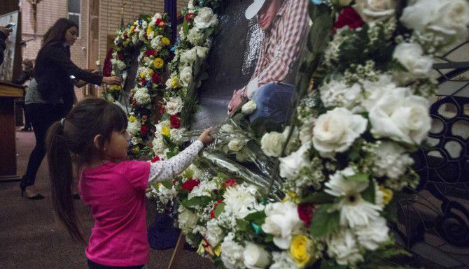 Una niña deja flores durante un servicio funeral en Los Ángeles por la muerte del cantante...