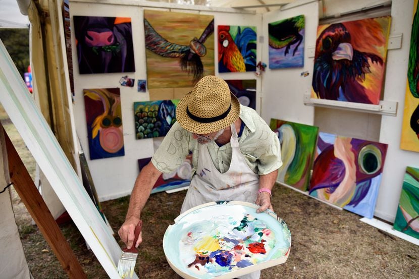 An artist paints his work at a Dallas arts festival.