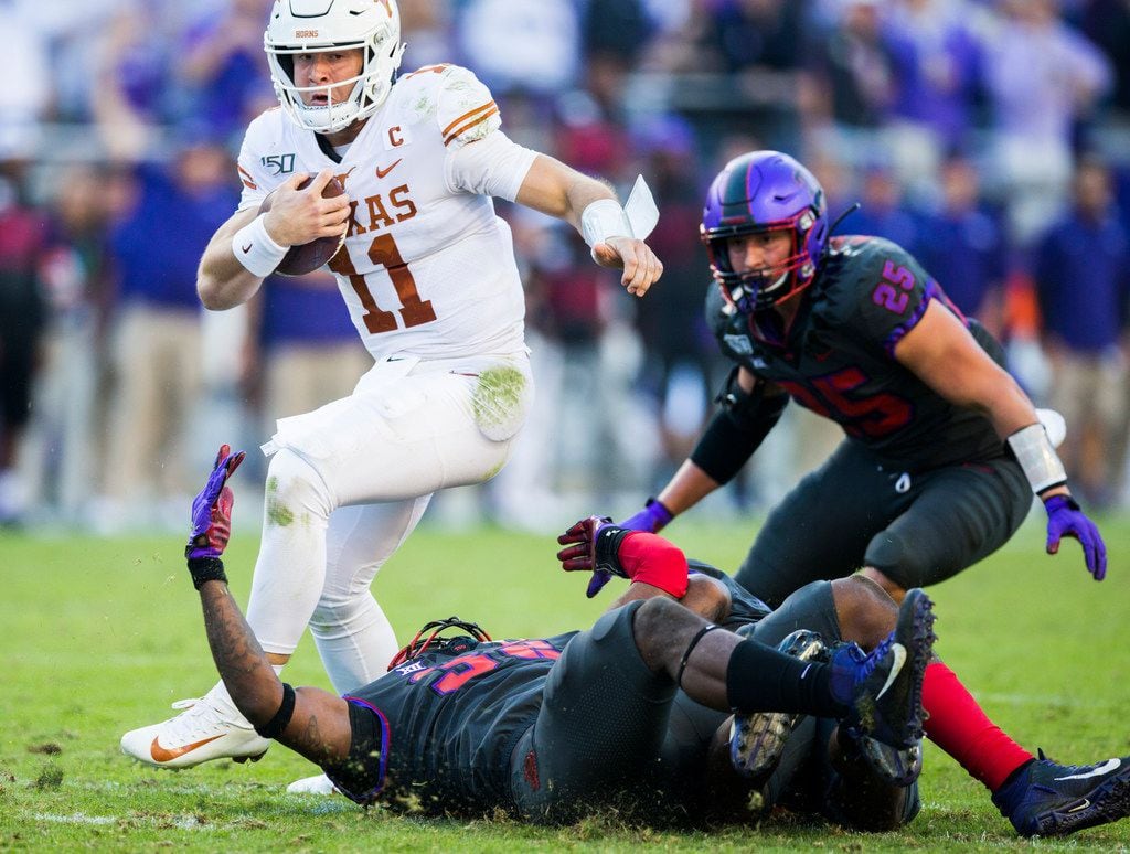 Texas Longhorns quarterback Sam Ehlinger (11) avoids a tackle by TCU Horned Frogs defensive end Ochaun Mathis (32) during the third quarter of an NCAA football game between the University of Texas and TCU on Saturday, October 26, 2019 at Amon G Carter Stadium in Fort Worth. (Ashley Landis/The Dallas Morning News)