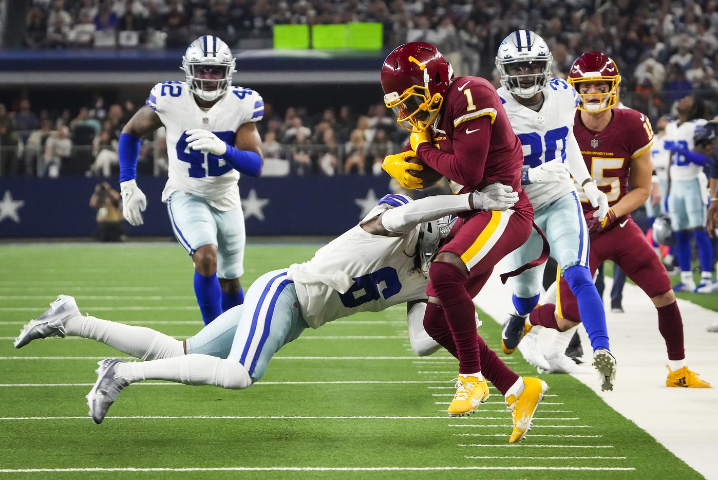 Washington Football Team wide receiver DeAndre Carter (1) is pushed out of bounds by Dallas Cowboys safety Donovan Wilson (6) during the first half of an NFL football game at AT&T Stadium on Sunday, Dec. 26, 2021, in Arlington.